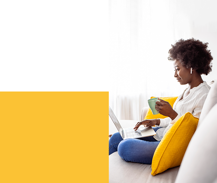 Self care Woman sitting with coffee mug and laptop on couch