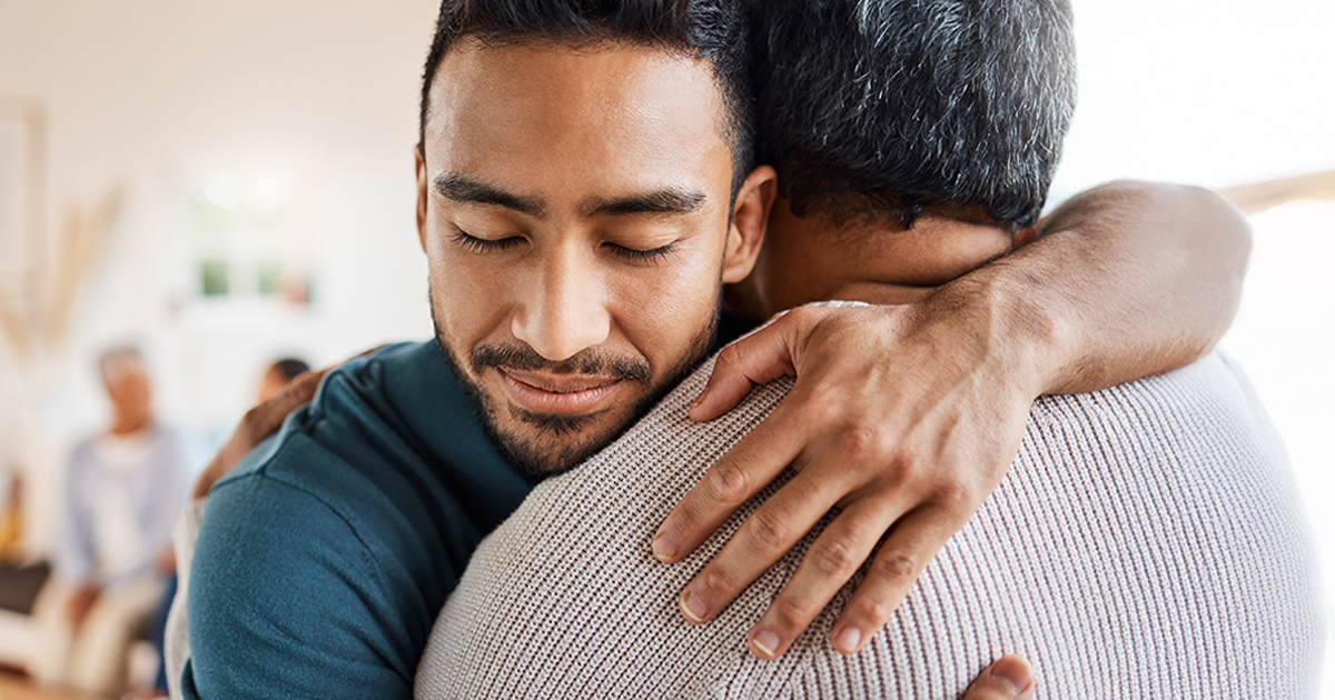 Two adults in a warm embrace.